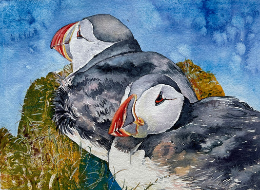 limitededition print from a mixed media painting of two puffins sitting on a grassy mound with the blue sea behind
