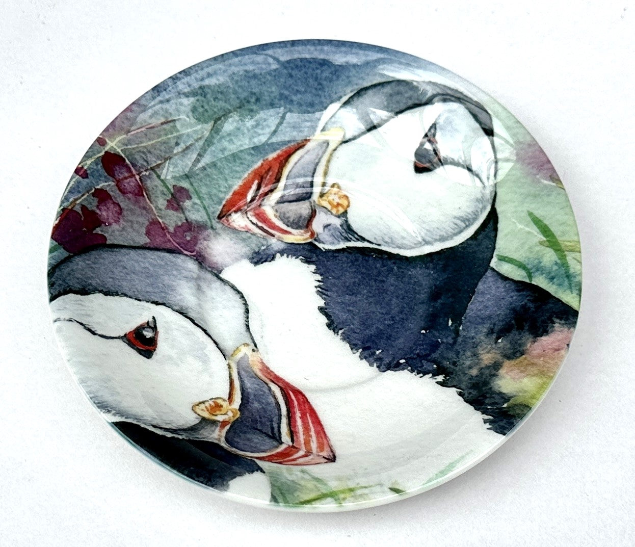 expresso saucer with a watercolour painting of two sea birds puffins