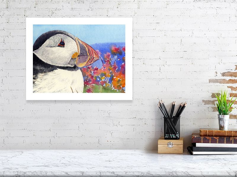 a limited edition print of a watercolour painting of a puffins head with its rainbow coloured beak and seapinks in the background