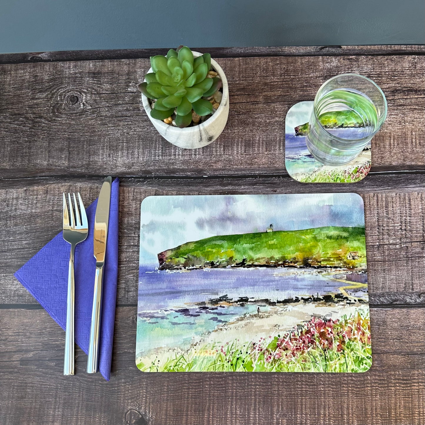 a tablemat with a watercolour painting of the brough of birsay
