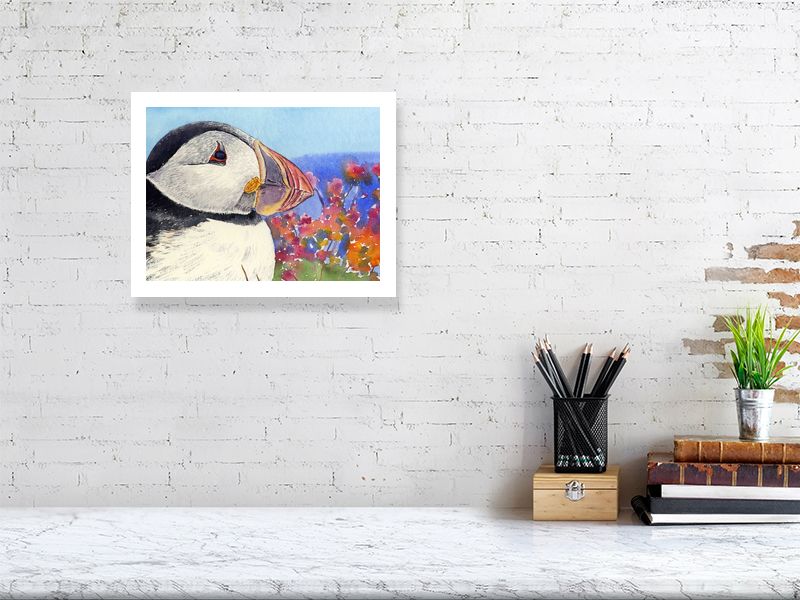 a limited edition print of a watercolour painting of a puffins head with its rainbow coloured beak and seapinks in the background