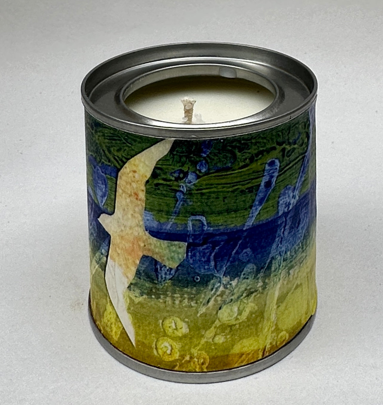 Small candle in a tin/Blue green yellow landscape with gull