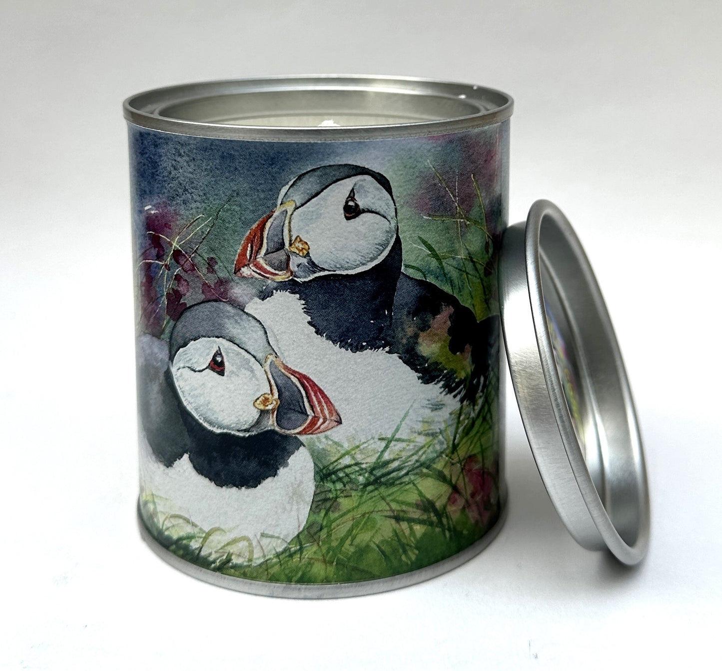 candle in a tin with a watercolour painting of two puffins