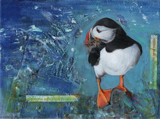 limited edition print from a mixed media painting of a puffin with bright orange feet and grass in his beak standing on a cliff with a blue sea background